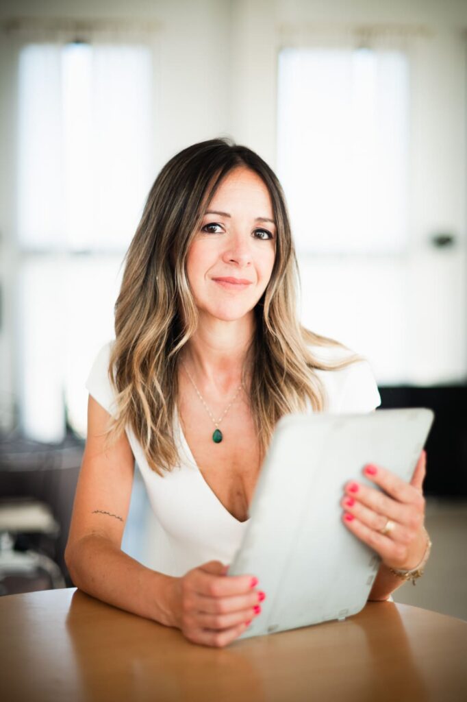 Ester Soto peluquera y maquilladora de novias con una tableta en la mano respondiendo a las preguntas frecuentes